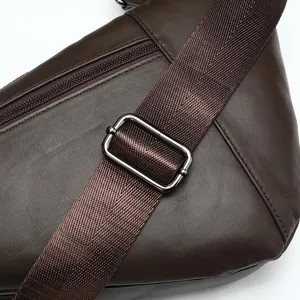 Close-up detail of brown leather crossbody bag strap buckle and zipper texture craftsmanship.