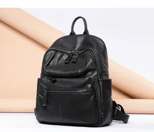 Black genuine cowhide leather backpack detail, multi-pocket design, premium texture.