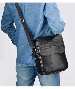 Detail view of men's black leather vertical shoulder bag worn crossbody for daily commute.