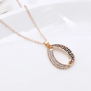 Primo piano dettagliato di una collana con ciondolo geometrico dorato e strass luminosi.