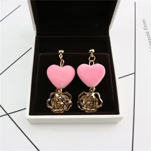 Sweet pink velvet heart and hollow rose crystal earrings detail shot in white jewelry box.