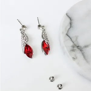 Detailopname van sprankelende rode kristallen oorbellen met heldere strass-steentjes zilver.