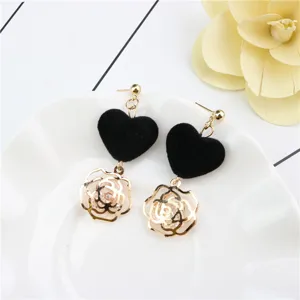 Detailed view of sweet black velvet heart and gold hollow rose zircon stud earrings.
