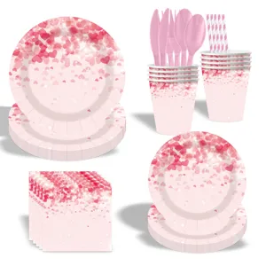 Ensemble de vaisselle de fête rose cœur avec assiettes, tasses, serviettes et couverts.