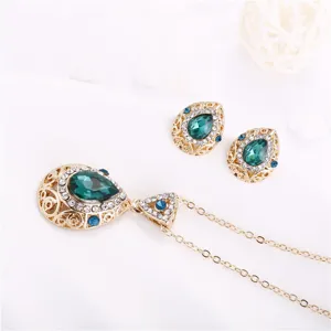 Detail view of vintage teardrop crystal necklace and earrings set with gold-tone finish.