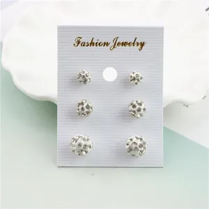 Close-up of white Shamballa rhinestone ball stud earrings detail, elegant sparkling crystal design.