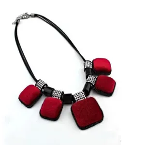 Gros plan pendentif carre en velours rouge avec cordon noir et espaceurs en strass chic.