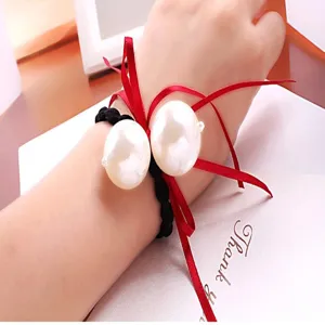 Chouchou de style coreen avec de grandes perles et un noeud ruban rouge, vue detaillee.