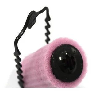 Vue de détail d'un bigoudi en mousse rose avec pince en plastique noir pour un coiffage facile.