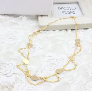 Detalle de accesorio para el pelo de cadena de metal dorado con lentejuelas redondas y diseño.