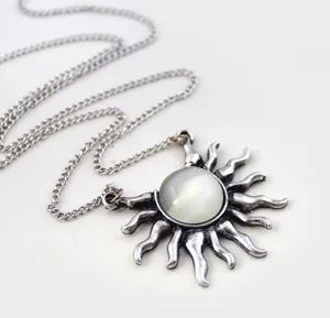 Vintage sun pendant necklace with silver chain detail close up shot for fashion jewelry