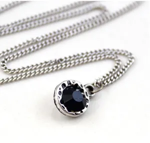 Vintage silver-tone metal necklace featuring a round black crystal pendant for women.