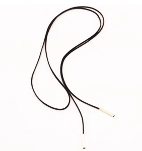 Detalles de un collar corbata de terciopelo negro con extremos de tubo de metal dorado.