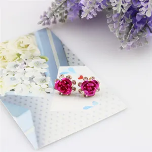 Gedetailleerd overzicht van trendy fuchsia roos kristal oorknopjes met sprankelende strass-steentjes.