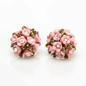 Detailopname van bolvormige roze keramische bloemoorstekers met schitterende strass.