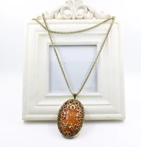 Lunga collana vintage con ciondolo in ambra ovale e dettagli di strass traforati.