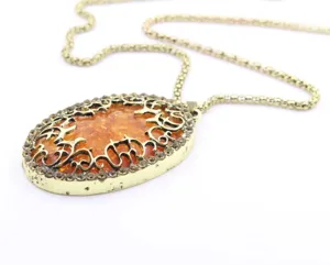 Collana lunga vintage color oro con ovale ambra e dettagli in strass eleganti.