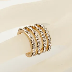 Gedetailleerd overzicht van de stijlvolle meerrijige strass gouden knokkelring, glanzend.