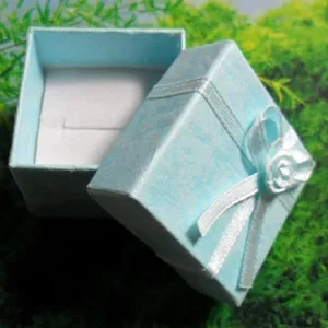 Vista detallada de la caja de regalo de anillo azul claro con lazo blanco, excelente presentación.