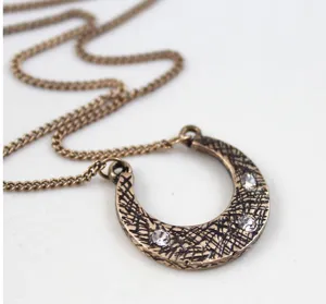 Vintage bronze horseshoe pendant necklace detail shot, featuring sparkling rhinestones.