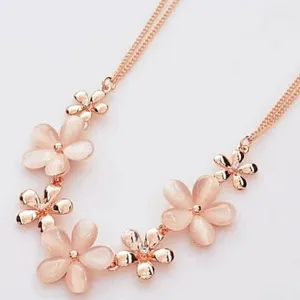 Close-up detail of a rose gold cat eye stone daisy flower necklace short collarbone