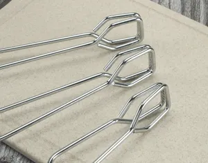 Detailed view of stainless steel kitchen food tongs, showing sturdy metal clip structure and design.