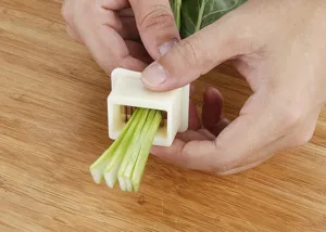 Detailansicht des Gemüseschneiders mit scharfen Klingen beim Schneiden von Bohnen.