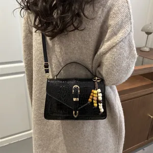 Detailed view of stylish women's black crocodile pattern shoulder and crossbody handbag.