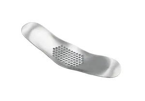 Stainless steel garlic press detail showing perforated grinding surface and curved handle design.