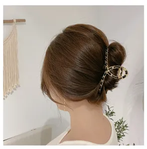 Detailed view of the elegant metal hair claw clip featuring a chic woven chain design for women.