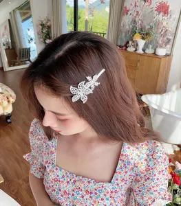 Gros plan sur l'épingle à cheveux fleurie en strass étincelante, pince latérale élégante.