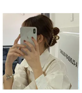Gold chain hair claw clip for women, elegant metal shark clip for styling thick hair.