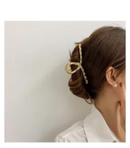 Detailed view of elegant hair claw clip, metal and fabric interwoven design for women hair styling.