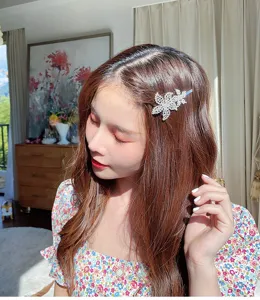 Gros plan détaillé d'une pince à cheveux florale en strass étincelante portée par le modèle.