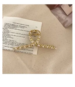 Exquisite gold metal chain hair claw clip with woven leather detail, elegant vintage design.