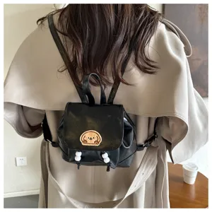Detailed view of mini black leather backpack with cute puppy patch and white bead drawstrings.