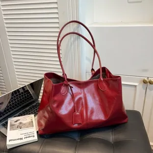 Rote glänzende Leder-Tote-Bag Detailansicht, minimalistisches Großraum-Design mit zwei Henkeln.