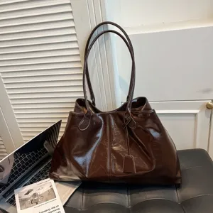 Detailaufnahme einer vintage braunen Shopper Tasche aus glänzendem PU Leder für Damen.
