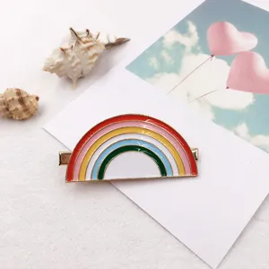 Close-up detail of a colorful enamel rainbow hair clip, featuring a cute duckbill clip design.