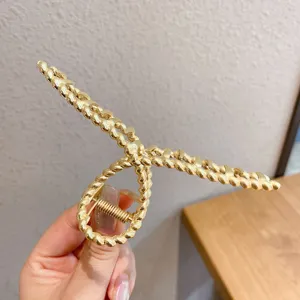 Gold metal hair claw clip with unique twisted design for elegant hairstyles and daily wear.