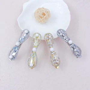 Rhinestone pearl bow hair clips set, detail view of sparkling crystal side hair pins for women.
