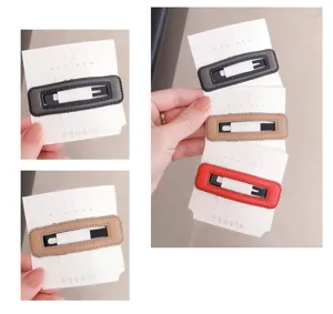 Minimalist rectangular leather hair clip detail shot, elegant solid color fringe side clip.