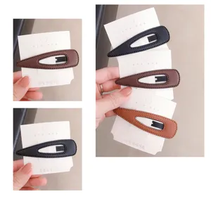 Detail view of minimalist leather teardrop hair clips, showcasing exquisite texture and clips.