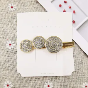 Rhinestone metal hair clip with three dazzling circular designs on card display detail.