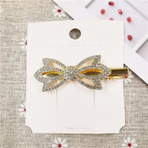 Close-up detail shot of a sparkling rhinestone bow hair clip displayed on white card.