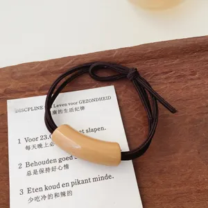 Minimalist milk tea color hair tie with curved tube decor for sweet daily hairstyles.