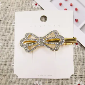 Rhinestone bow hair clip detail shot, showing sparkling crystals and gold metal duckbill.