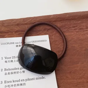 Minimalist black glossy plaque hair tie detail, elegant elastic hair band for daily styling.