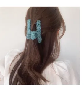 Vue détail pince à cheveux en mousseline bleu clair, accessoire élégant et froncé.