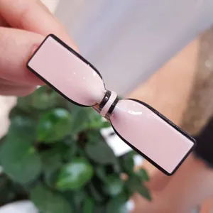 Close-up view of the pink acrylic bow hair clip showing detailed glossy surface and edge.
